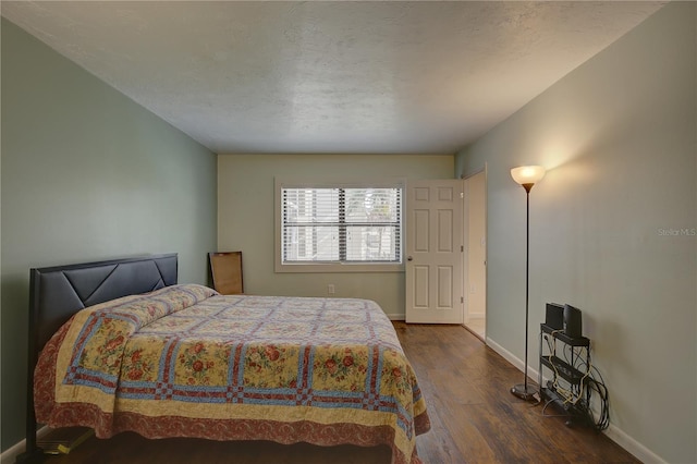 bedroom featuring dark hardwood / wood-style floors and a textured ceiling