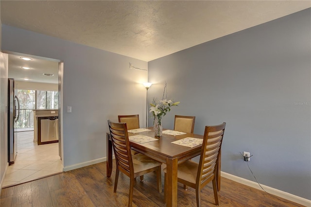 dining room featuring light hardwood / wood-style flooring and a textured ceiling