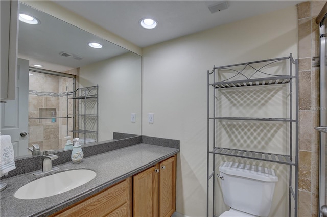 bathroom with toilet, an enclosed shower, and vanity