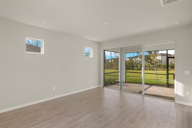 empty room with light hardwood / wood-style flooring