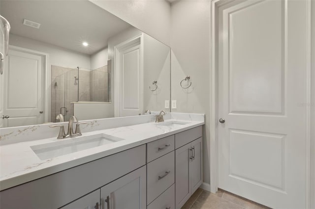 bathroom with tile patterned floors, a shower with door, and vanity