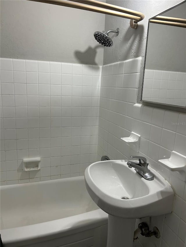 bathroom featuring tile walls and tiled shower / bath