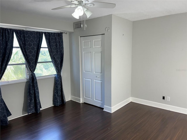 unfurnished bedroom featuring ceiling fan, dark hardwood / wood-style flooring, and a closet