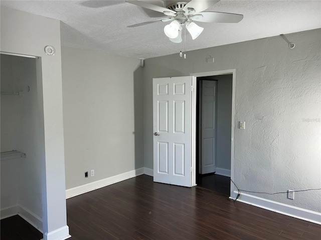 unfurnished bedroom featuring ceiling fan, dark hardwood / wood-style flooring, and a textured ceiling