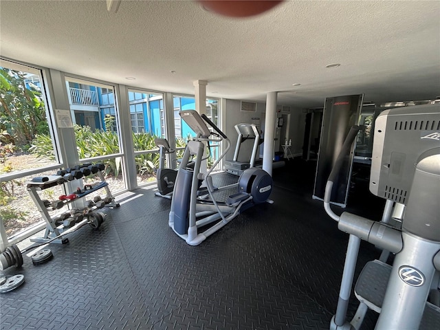 workout area with floor to ceiling windows and a textured ceiling