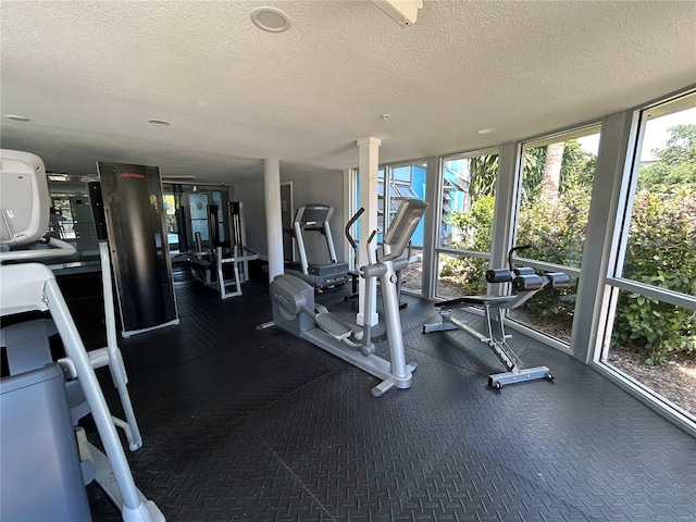 exercise room with floor to ceiling windows and a textured ceiling