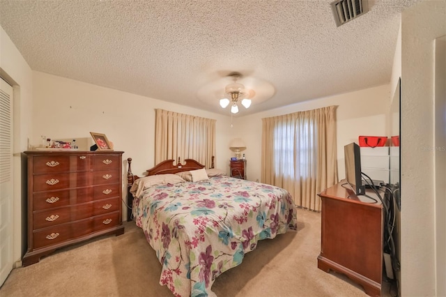 bedroom with ceiling fan, a textured ceiling, and carpet floors