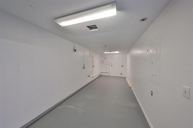 corridor with a textured ceiling and concrete floors