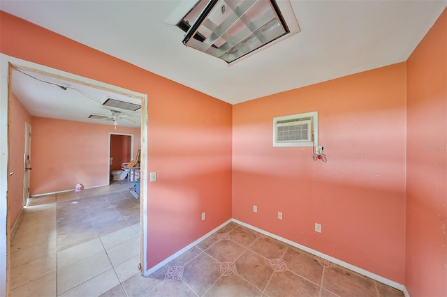 spare room featuring a wall mounted AC, ceiling fan, and tile patterned flooring