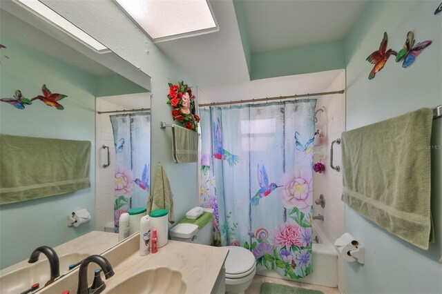 full bathroom with shower / bath combination with curtain, a skylight, vanity, and toilet