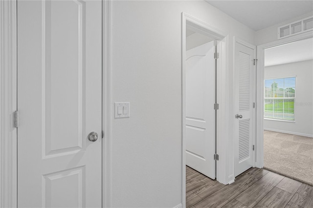 hallway with light hardwood / wood-style floors