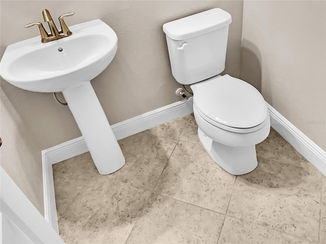 bathroom featuring toilet and tile patterned flooring