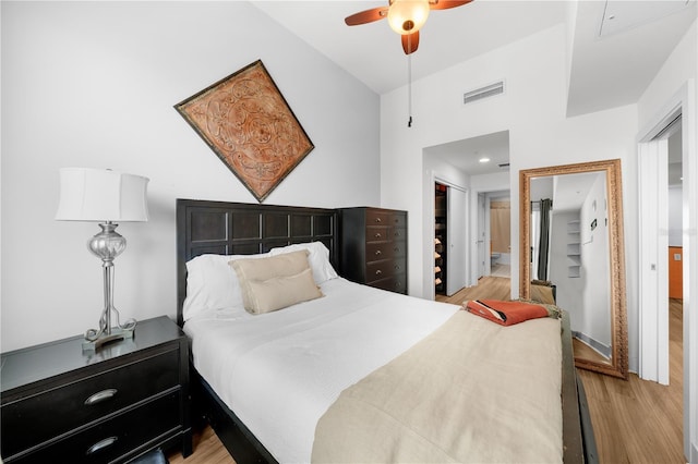 bedroom featuring visible vents, a closet, wood finished floors, ensuite bathroom, and ceiling fan