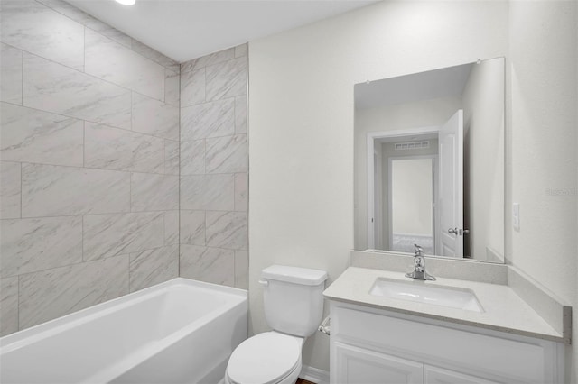 full bathroom with tiled shower / bath, vanity, and toilet