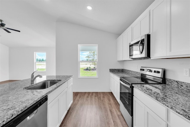 kitchen featuring light wood-type flooring, stainless steel appliances, sink, ceiling fan, and vaulted ceiling