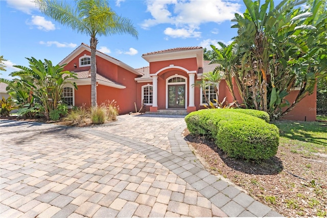 mediterranean / spanish-style house featuring a tile roof and stucco siding