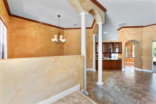 interior space with arched walkways, crown molding, decorative columns, an inviting chandelier, and baseboards