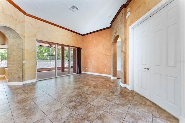 empty room featuring crown molding and tile patterned floors