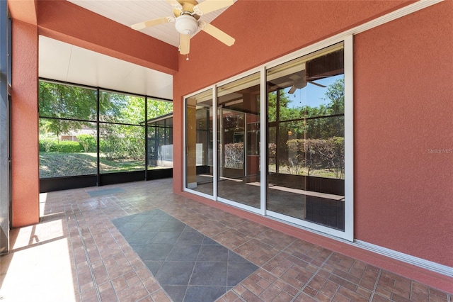 unfurnished sunroom featuring ceiling fan