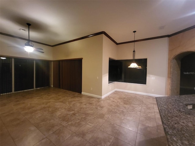 unfurnished room featuring baseboards, visible vents, arched walkways, ceiling fan, and ornamental molding