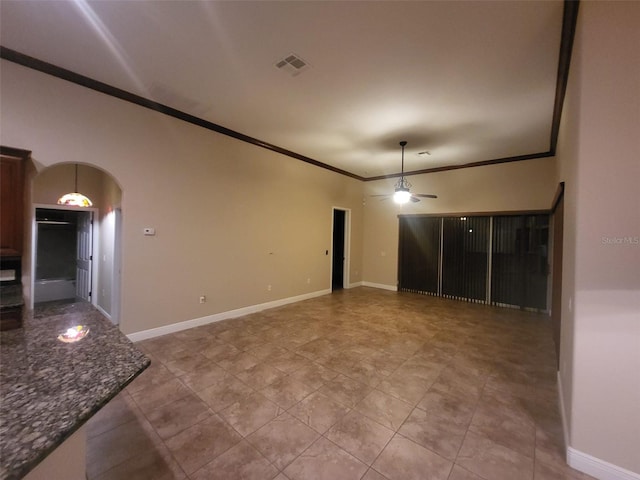 tiled spare room featuring ceiling fan and crown molding