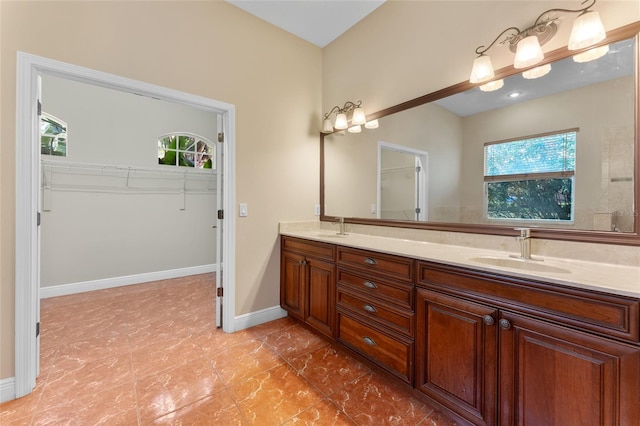 bathroom with tile patterned floors, double vanity, and a healthy amount of sunlight