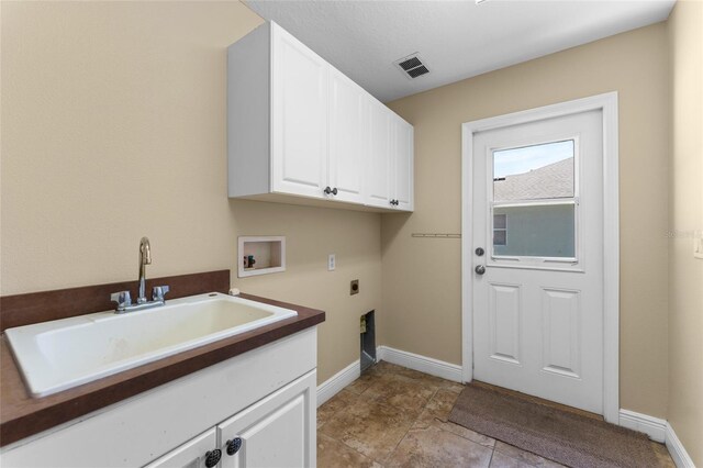 laundry area featuring cabinets, electric dryer hookup, washer hookup, light tile patterned floors, and sink