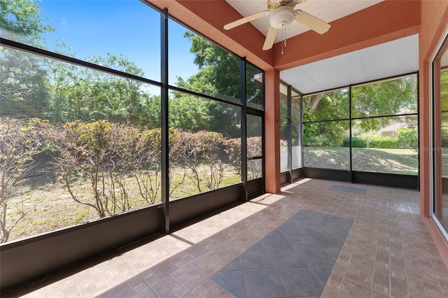 unfurnished sunroom featuring ceiling fan