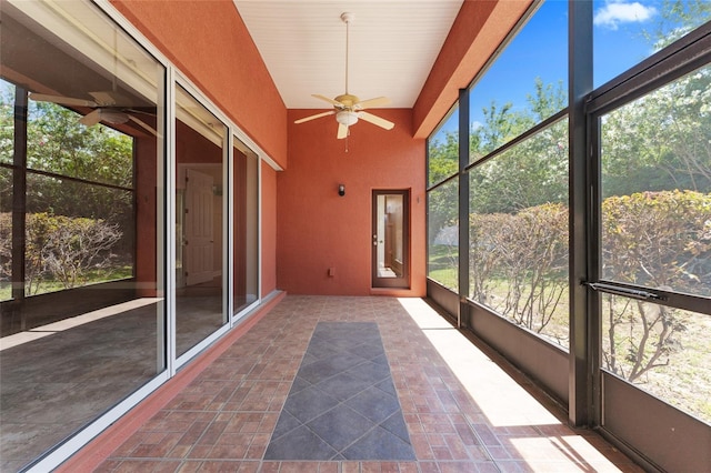 unfurnished sunroom featuring ceiling fan and plenty of natural light