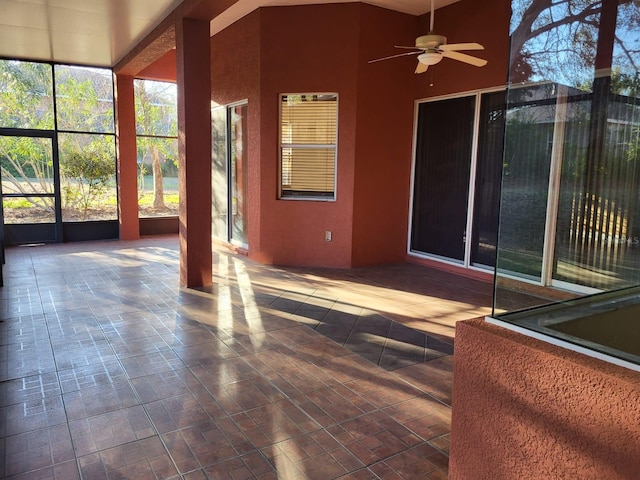 unfurnished sunroom featuring ceiling fan