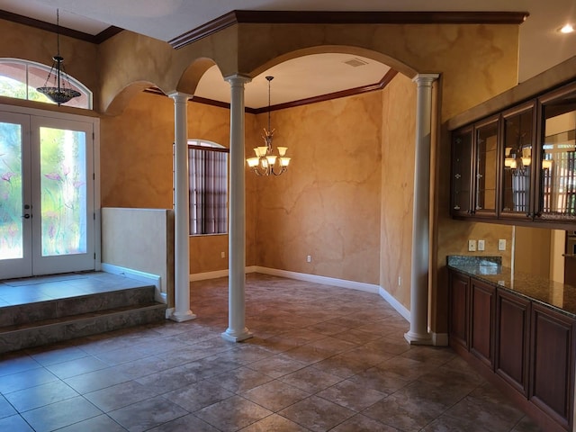 entryway featuring visible vents, arched walkways, baseboards, ornamental molding, and ornate columns