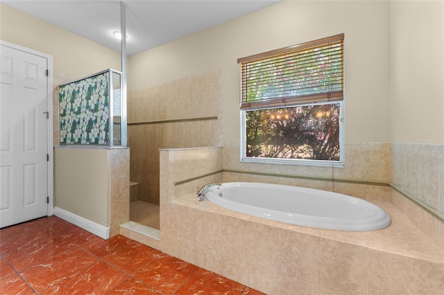 bathroom with a walk in shower, tile patterned flooring, and a garden tub