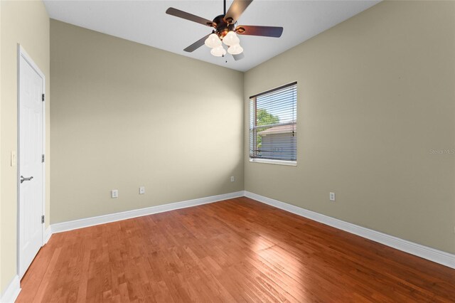 spare room with a ceiling fan, light wood-style flooring, and baseboards