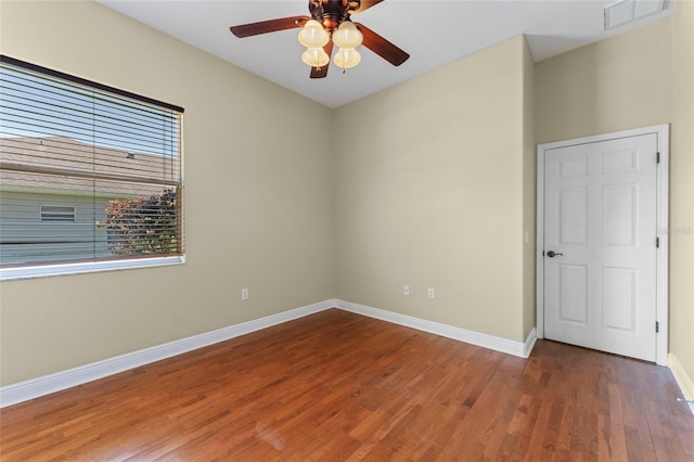 unfurnished room with a ceiling fan, baseboards, visible vents, and wood finished floors