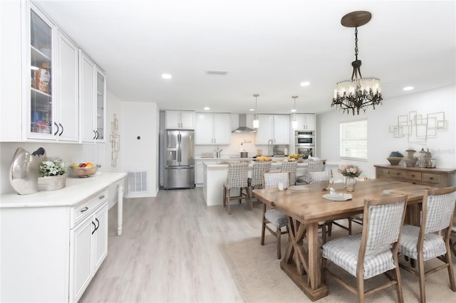 dining area featuring light hardwood / wood-style floors and an inviting chandelier