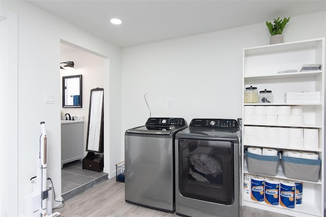 washroom with independent washer and dryer and light hardwood / wood-style flooring