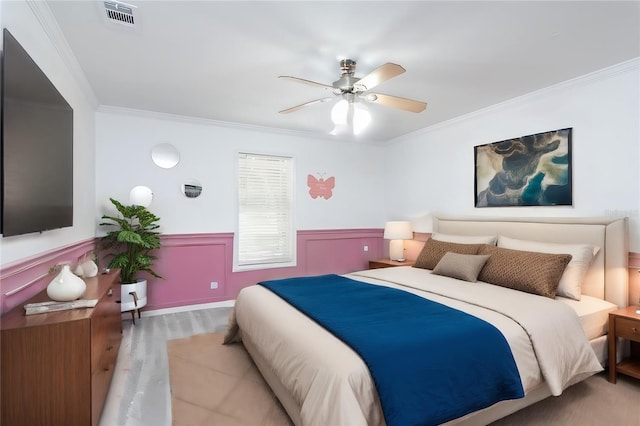 bedroom with hardwood / wood-style floors, ceiling fan, and ornamental molding