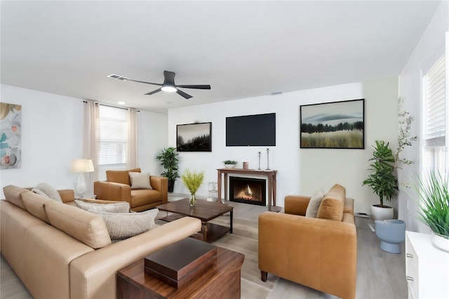 living room with light hardwood / wood-style flooring and ceiling fan