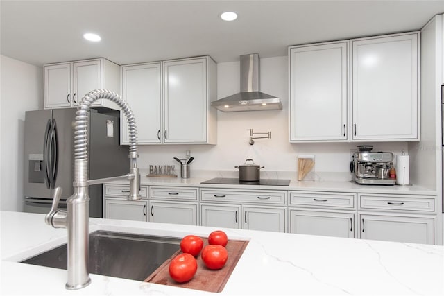 kitchen with white cabinetry, sink, wall chimney exhaust hood, stainless steel fridge with ice dispenser, and black electric stovetop