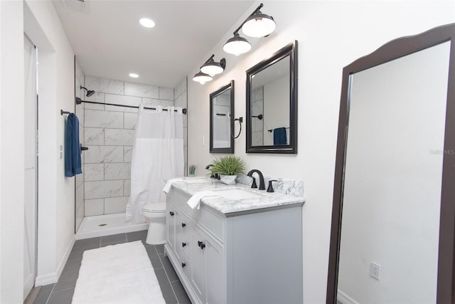 bathroom with tile patterned floors, vanity, toilet, and walk in shower