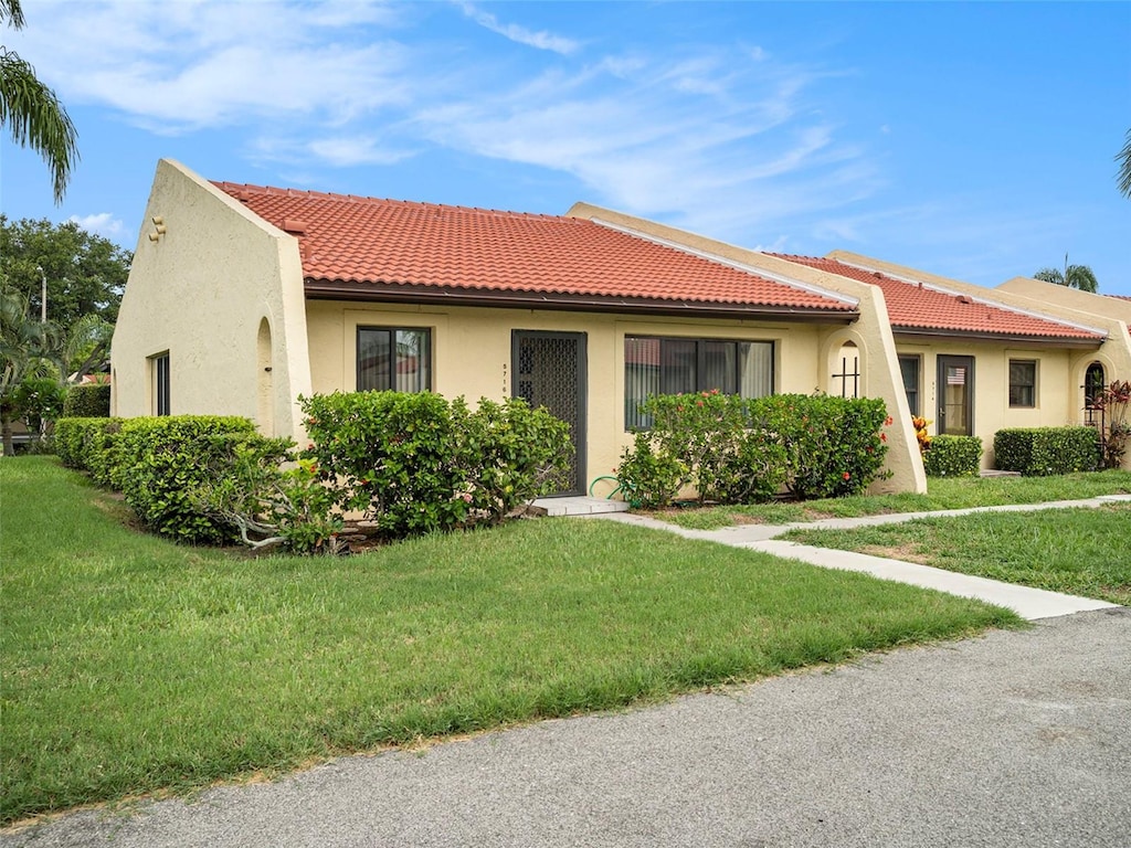 mediterranean / spanish home with a front yard