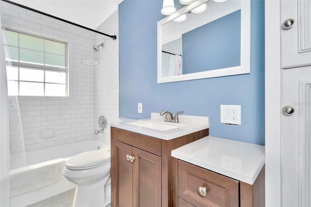 full bathroom with toilet, vanity, and tiled shower / bath combo