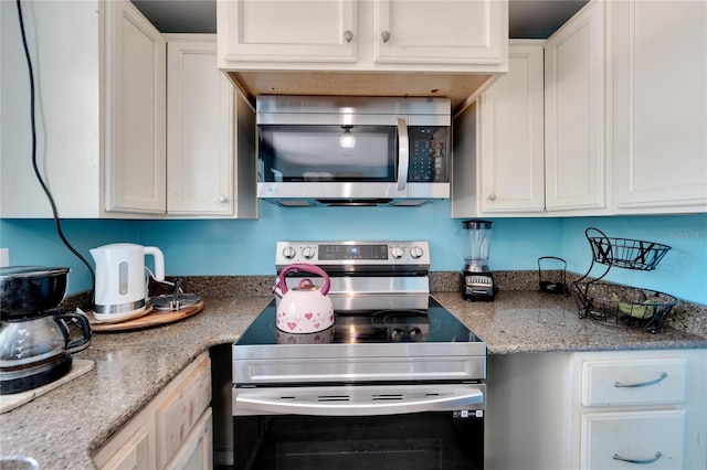 kitchen with white cabinetry, appliances with stainless steel finishes, and light stone countertops