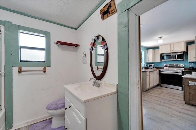 bathroom featuring a textured ceiling, toilet, oversized vanity, and hardwood / wood-style floors