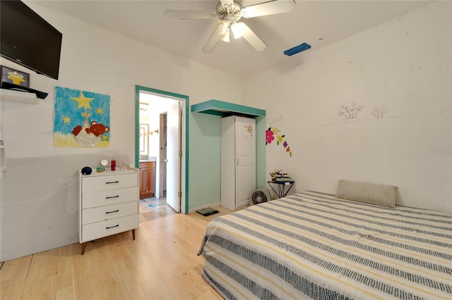 bedroom with ceiling fan, ensuite bathroom, and light hardwood / wood-style flooring