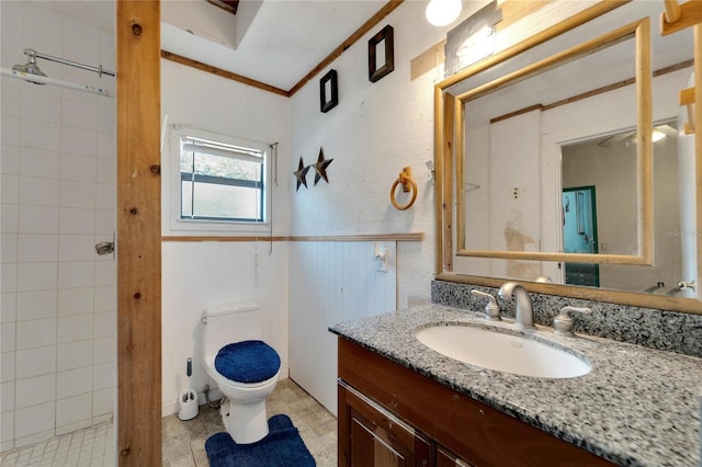 bathroom with tile flooring, vanity, toilet, and ornamental molding