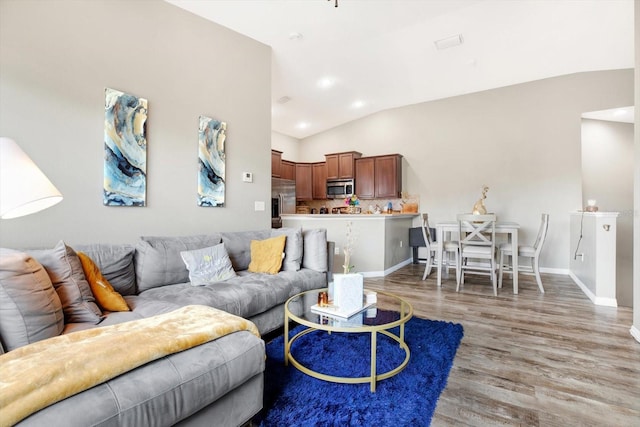 living room with hardwood / wood-style floors and vaulted ceiling