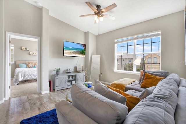 living room featuring light hardwood / wood-style flooring, ceiling fan, and vaulted ceiling