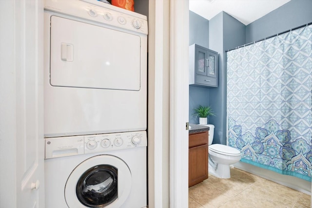 washroom featuring stacked washer and clothes dryer and light tile patterned floors