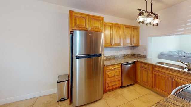 kitchen with sink, light stone countertops, light tile floors, and stainless steel appliances